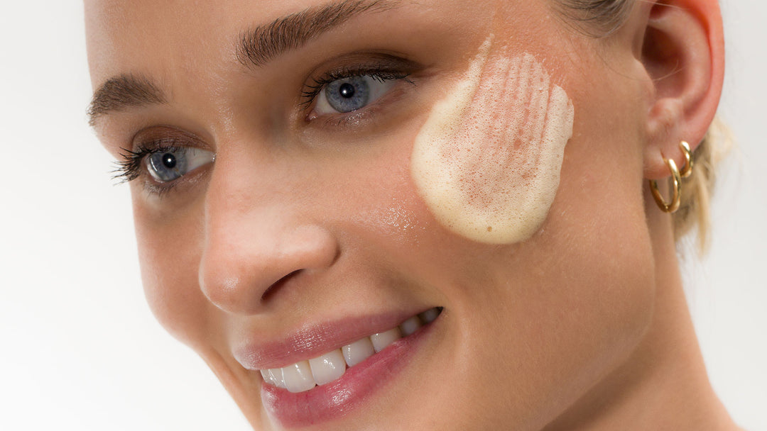 Woman applying Bio-Therapeutic Aqua Foam Peel product to her face with a close-up of her eye and cheek.